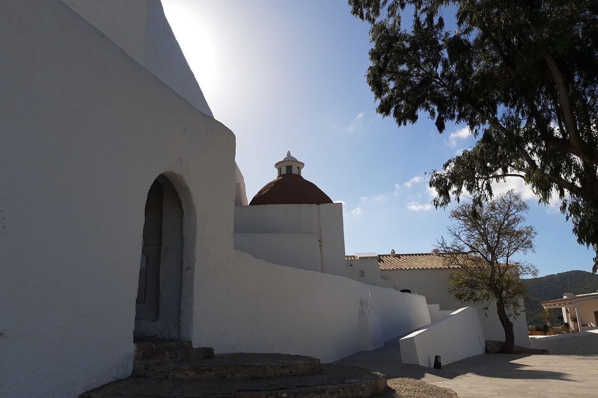 The whitewashed church and harbourfront of Santa Eulària des Riu with calm blue sea, east coast of Ibiza